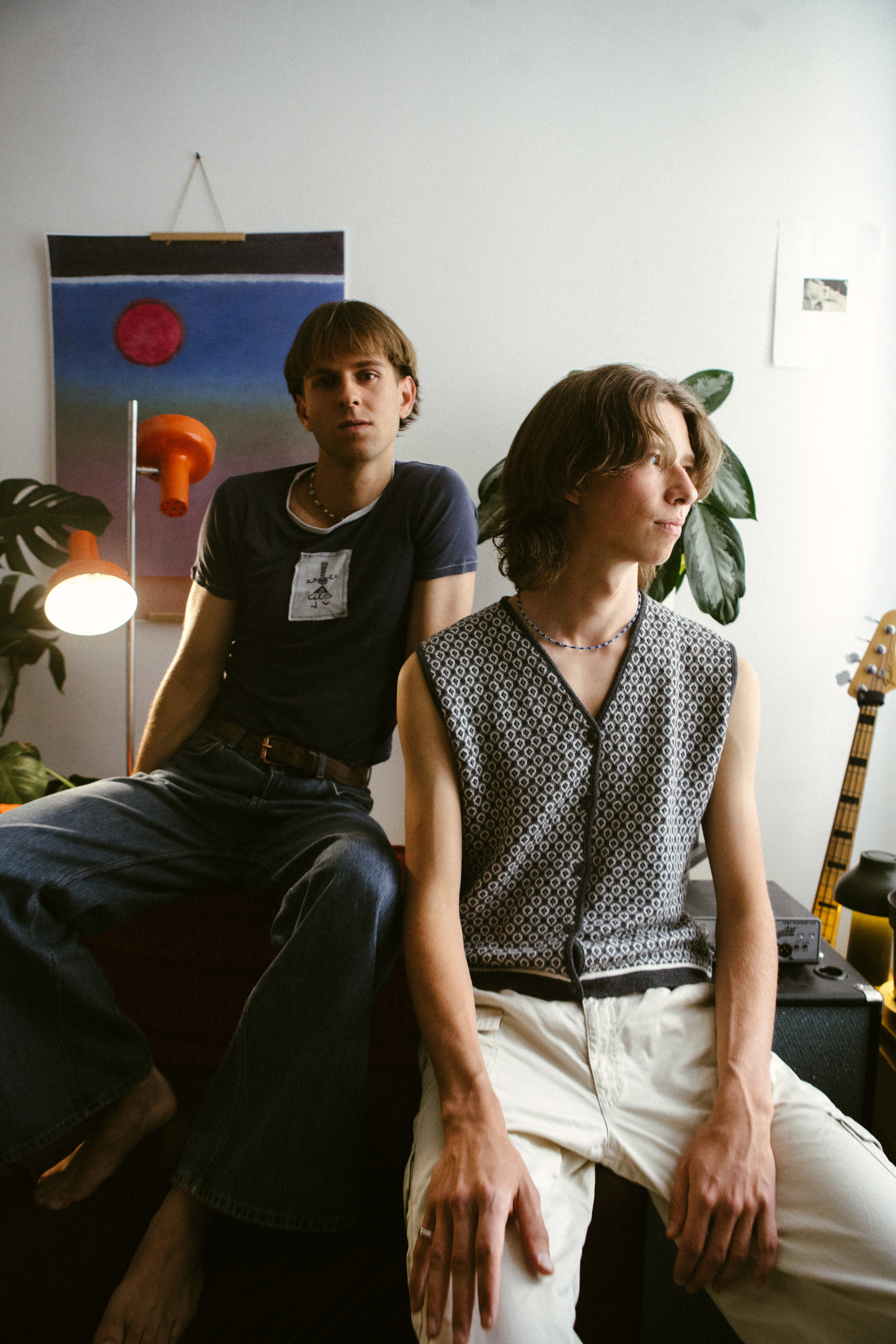 Auf dem Bild sind die beiden Bandmitglieder Josch und Finn von Zimmer90 zu sehen, die in einem Raum in gemütlicher Atmosphäre entspannt in Richtung der Kamera sitzen.