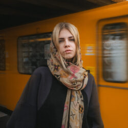 Das Foto zeigt die Sängerin Ellice vor einem abfahrenden Zug.